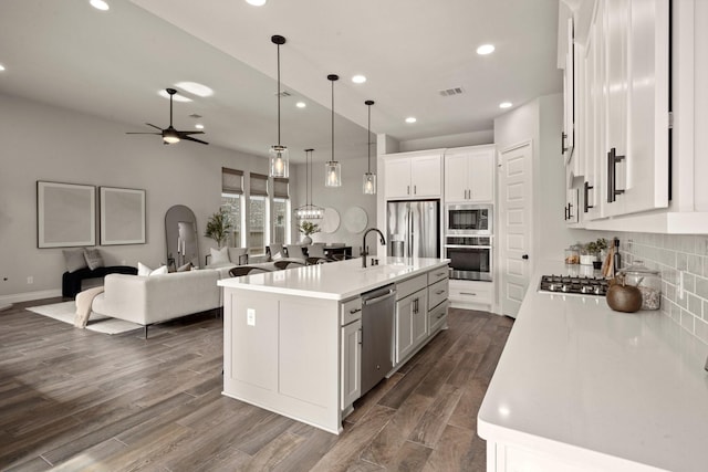 16711 Arboleda Dr, Humble, TX 77346 - kitchen featuring stainless steel appliances, recessed lighting, white cabinetry, light countertops, and dark wood-style flooring