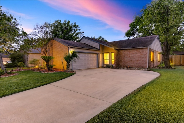 view of front of house with a lawn, brick siding, and a garage
