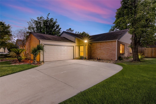 ranch-style home featuring brick siding, a front lawn, an attached garage, and driveway