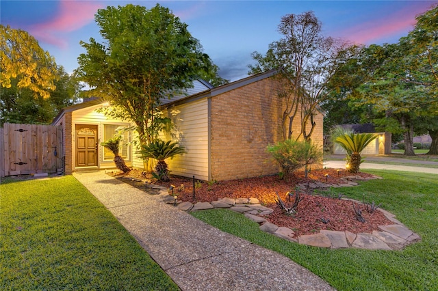 mid-century modern home with fence, a front lawn, and brick siding