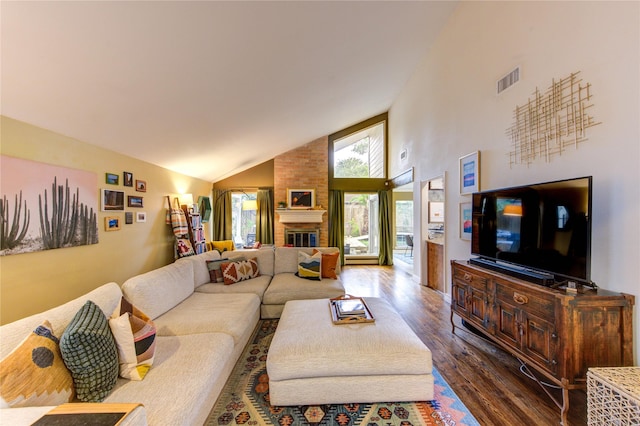 living room with high vaulted ceiling, a brick fireplace, dark wood finished floors, and visible vents