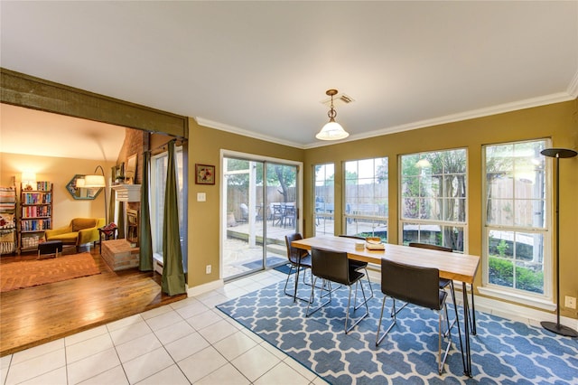 dining room featuring crown molding, baseboards, visible vents, and light tile patterned floors
