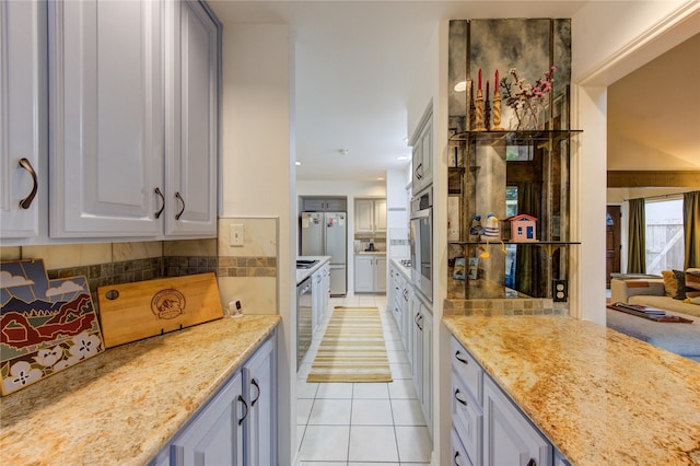 kitchen with light tile patterned floors, light stone countertops, backsplash, and high end fridge