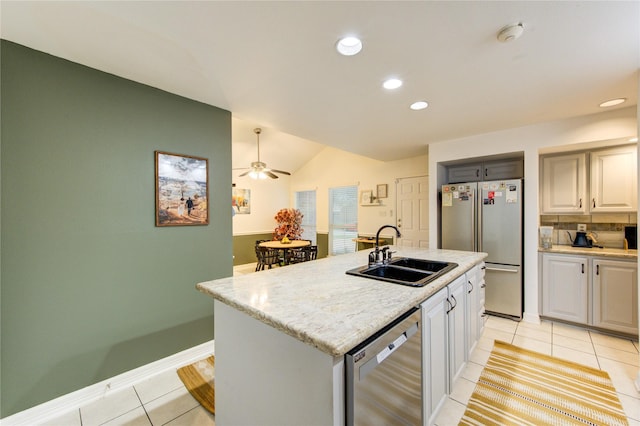 kitchen with light tile patterned flooring, recessed lighting, a sink, vaulted ceiling, and stainless steel appliances