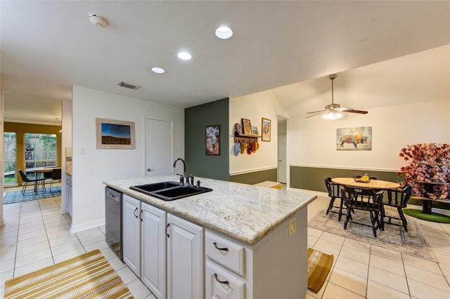 kitchen featuring black dishwasher, light tile patterned flooring, a sink, and a kitchen island with sink