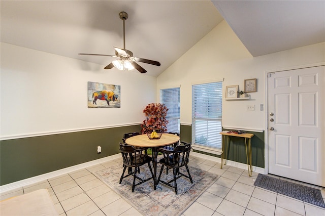dining space featuring light tile patterned floors, baseboards, a ceiling fan, and high vaulted ceiling