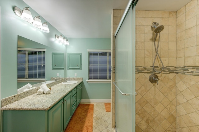 full bathroom with tile patterned floors, a shower stall, baseboards, and vanity