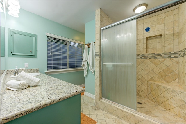 full bath with vanity, tile patterned flooring, and a stall shower