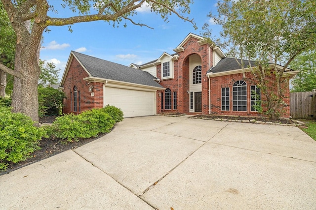 13907 Carrington Ln, Cypress, TX 77429 - traditional-style house featuring brick siding, an attached garage, driveway, fence, and roof with shingles