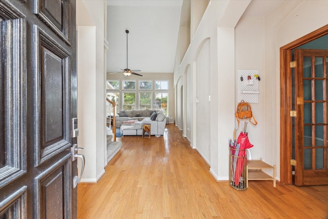 13907 Carrington Ln, Cypress, TX 77429 - entryway featuring light wood-style floors, ceiling fan, baseboards, and a towering ceiling