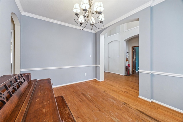 13907 Carrington Ln, Cypress, TX 77429 - unfurnished dining area with arched walkways, crown molding, a chandelier, wood finished floors, and baseboards
