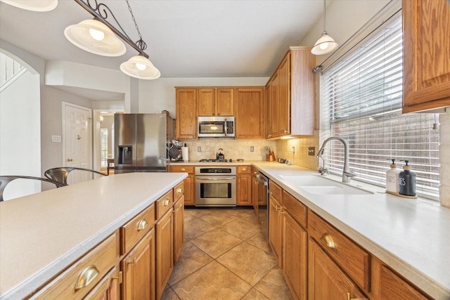 13907 Carrington Ln, Cypress, TX 77429 - kitchen with appliances with stainless steel finishes, a sink, tasteful backsplash, light countertops, and hanging light fixtures