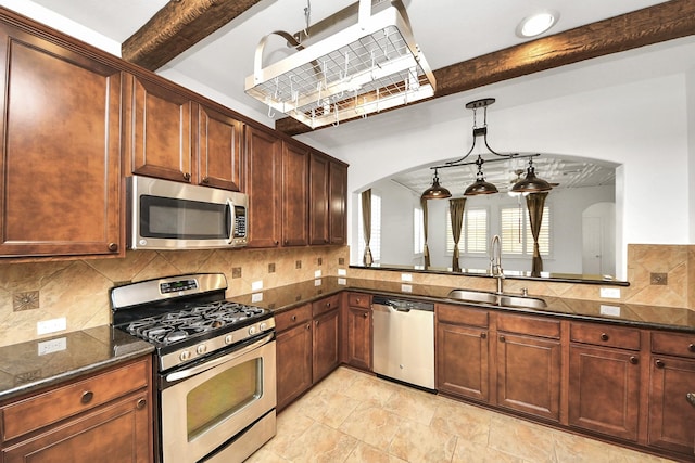 kitchen featuring appliances with stainless steel finishes, arched walkways, beamed ceiling, and a sink
