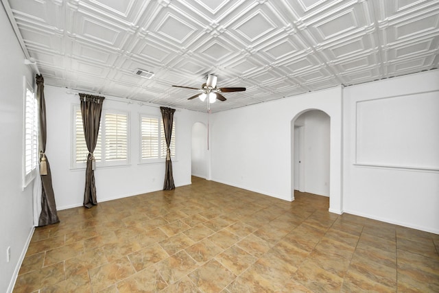 spare room with arched walkways, visible vents, a ceiling fan, and an ornate ceiling