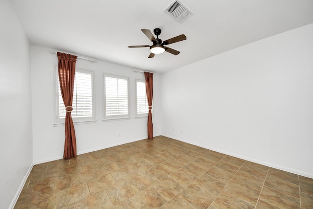 unfurnished room featuring visible vents, ceiling fan, stone finish floor, and baseboards