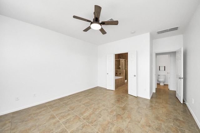 unfurnished bedroom with stone finish floor, ceiling fan, visible vents, ensuite bathroom, and baseboards