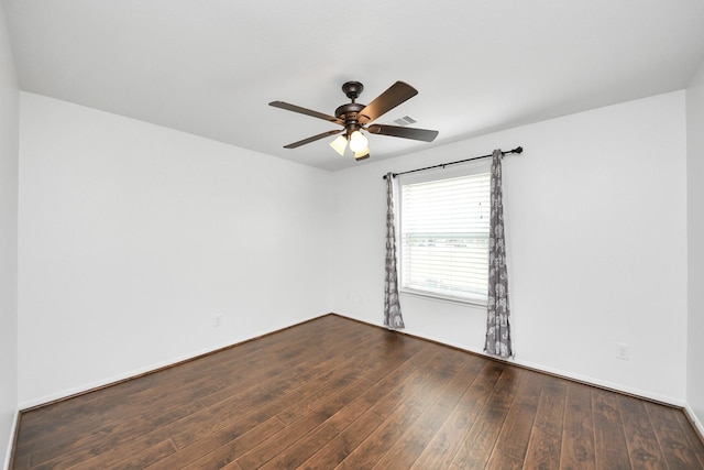 spare room featuring baseboards, visible vents, wood finished floors, and a ceiling fan