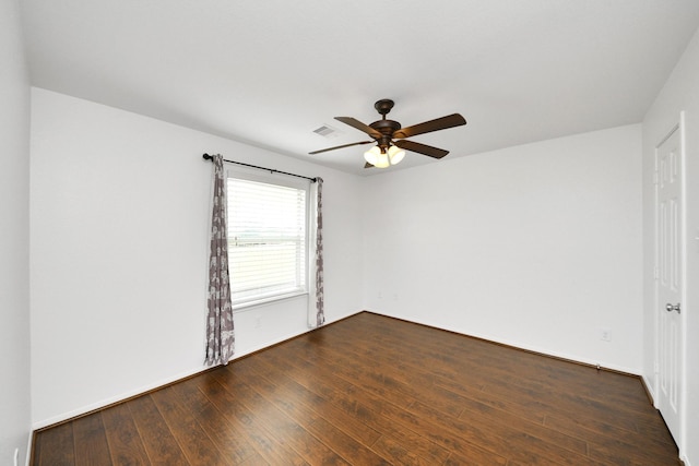 unfurnished room featuring visible vents, ceiling fan, and dark wood-style flooring