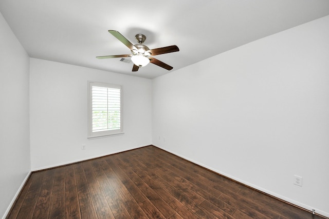 empty room featuring baseboards, a ceiling fan, and dark wood-type flooring