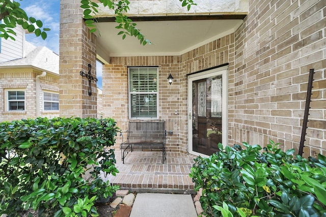 doorway to property with brick siding