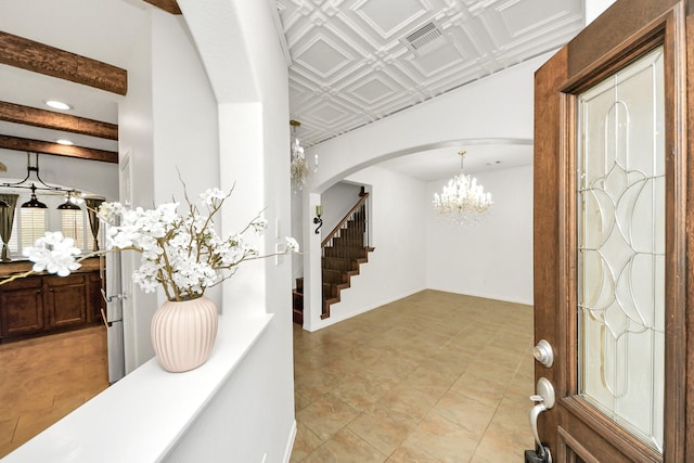 entrance foyer featuring visible vents, arched walkways, a chandelier, an ornate ceiling, and stairway