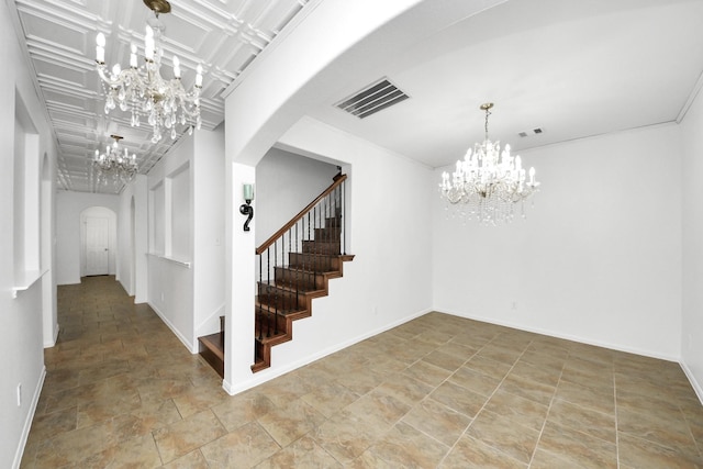 foyer entrance with an inviting chandelier, visible vents, stairs, and arched walkways