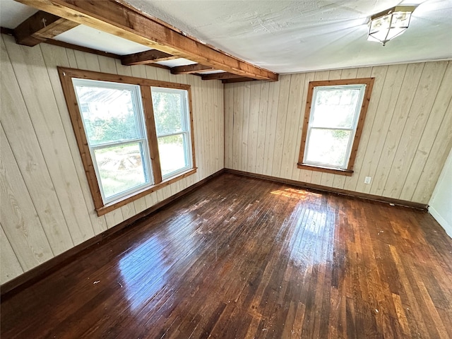 unfurnished room featuring dark wood-style flooring and wood walls