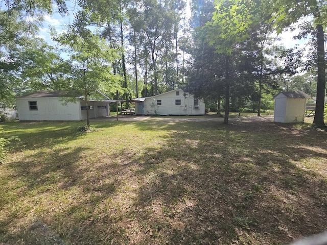 view of green lawn with an outdoor structure, a shed, and view of wooded area