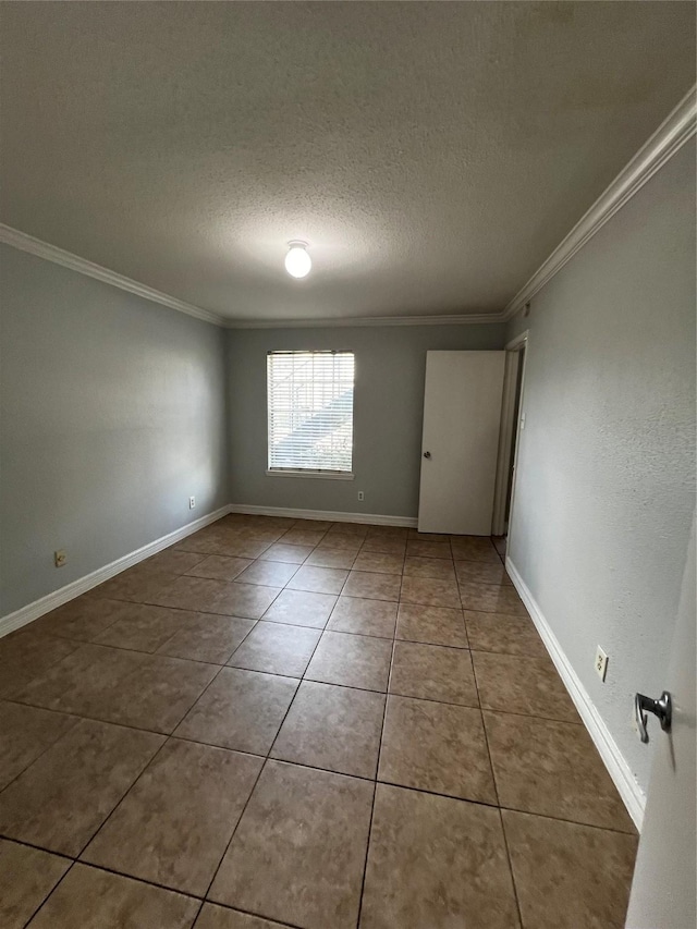tiled empty room with baseboards, ornamental molding, and a textured ceiling