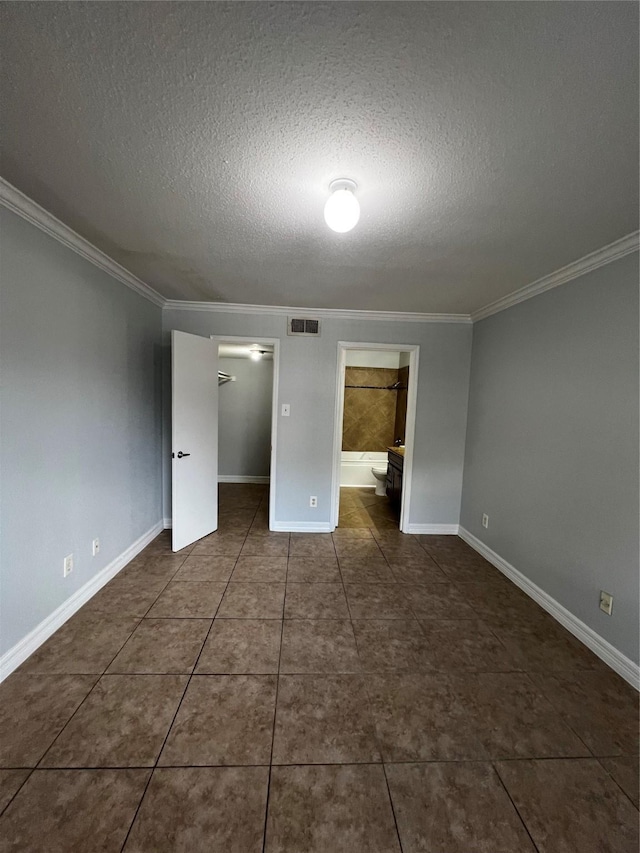 unfurnished bedroom featuring crown molding, a textured ceiling, and visible vents