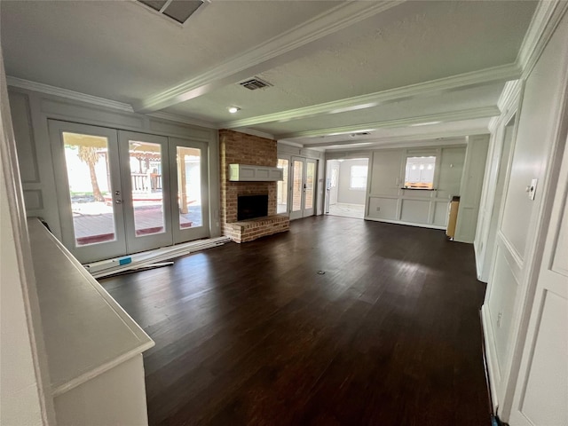 16418 York Minster Dr, Spring, TX 77379 - unfurnished living room with french doors, crown molding, dark wood-style flooring, beamed ceiling, and a brick fireplace