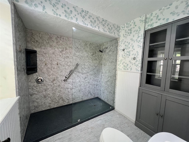 16418 York Minster Dr, Spring, TX 77379 - bathroom featuring toilet, wallpapered walls, walk in shower, wainscoting, and a textured ceiling