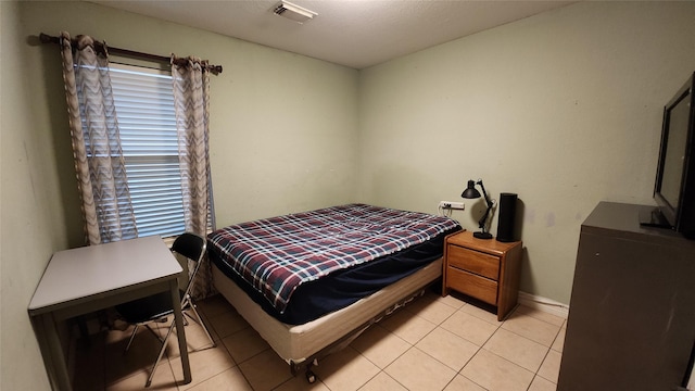 bedroom with light tile patterned floors, visible vents, and baseboards