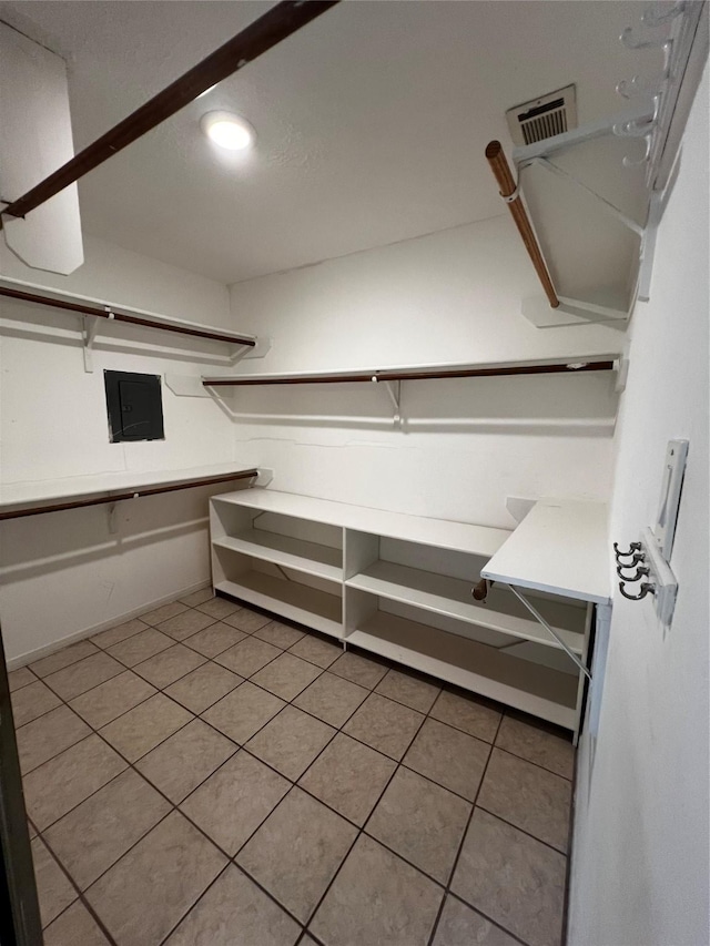 walk in closet with light tile patterned floors, visible vents, and electric panel