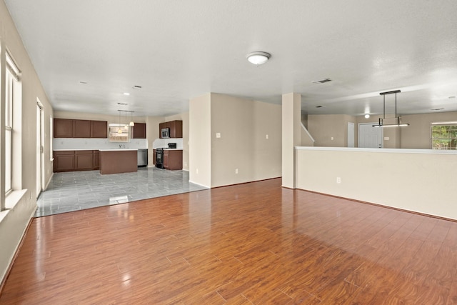 7931 Raven Creek Ln, Cypress, TX 77433 - unfurnished living room with baseboards, visible vents, and light wood-style floors