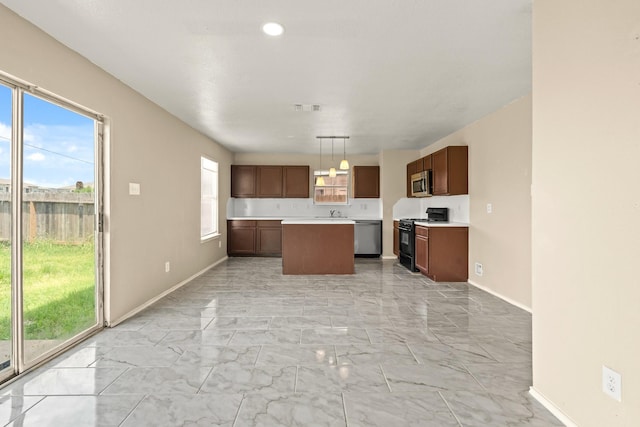 7931 Raven Creek Ln, Cypress, TX 77433 - kitchen featuring stainless steel appliances, light countertops, a kitchen island, baseboards, and marble finish floor