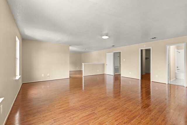 7931 Raven Creek Ln, Cypress, TX 77433 - unfurnished living room with light wood-style floors, visible vents, and baseboards