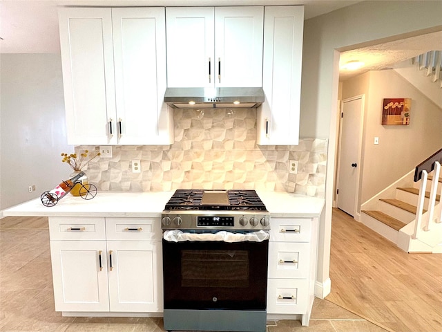 kitchen with white cabinets, stainless steel gas range oven, and under cabinet range hood