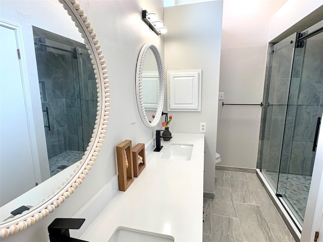 full bath with a sink, toilet, a stall shower, marble finish floor, and double vanity