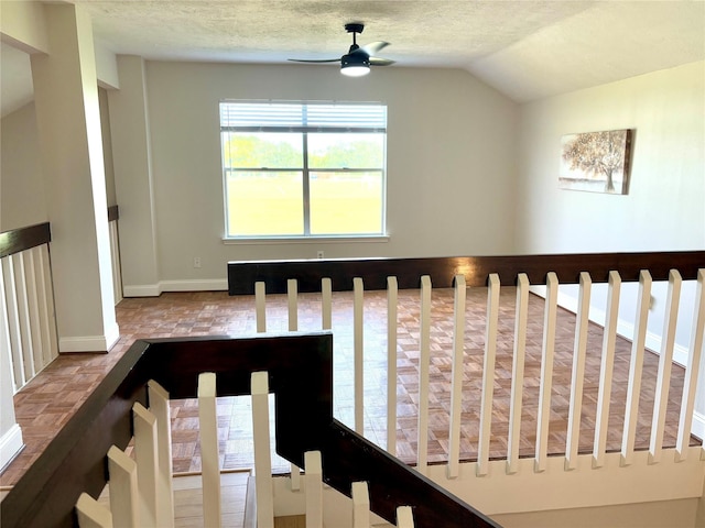 stairway with lofted ceiling, ceiling fan, and baseboards