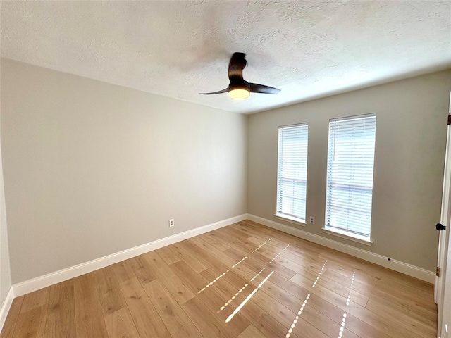 unfurnished room featuring a textured ceiling, ceiling fan, light wood finished floors, and baseboards