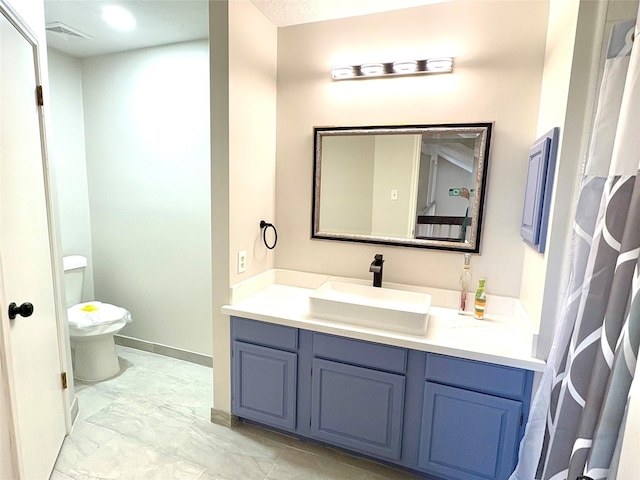 bathroom with visible vents, baseboards, toilet, vanity, and marble finish floor