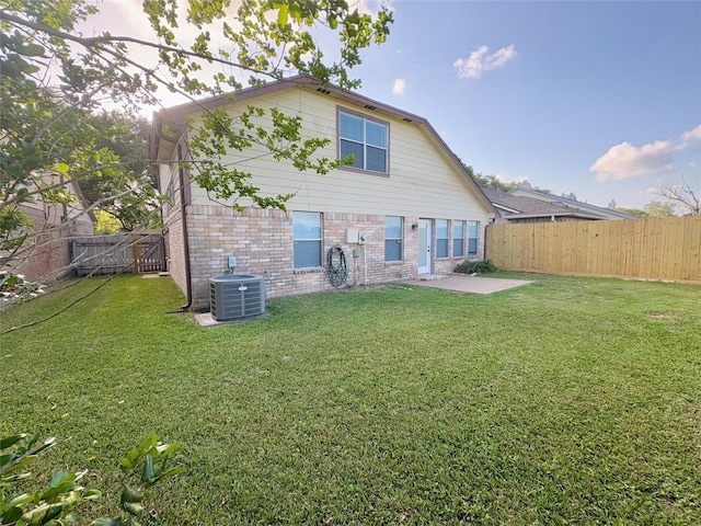 rear view of house featuring a patio, brick siding, a fenced backyard, and cooling unit