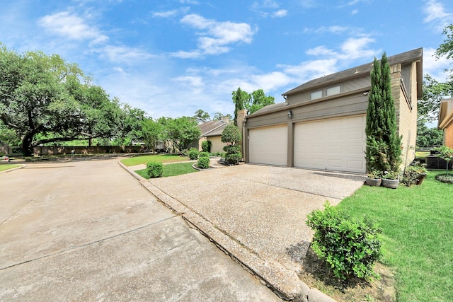 view of front of house with concrete driveway, a front yard, and an attached garage