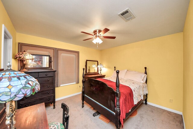 carpeted bedroom featuring a ceiling fan, visible vents, and baseboards