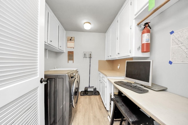 laundry room featuring washer and dryer, cabinet space, and light wood-style flooring