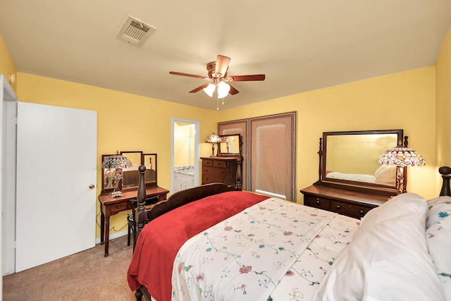 bedroom featuring visible vents, a ceiling fan, ensuite bath, and carpet