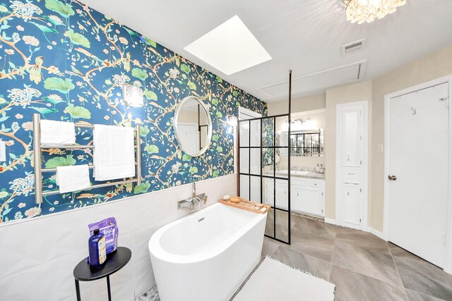 200 Old Bridge Lk, Houston, TX 77069 - bathroom featuring visible vents, vanity, wainscoting, wallpapered walls, and a soaking tub