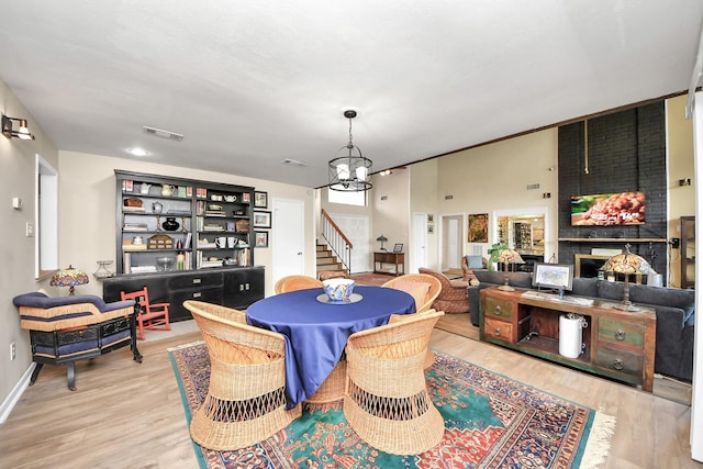 dining area featuring stairs, visible vents, wood finished floors, and a chandelier