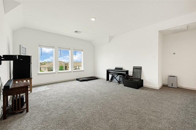 interior space with carpet flooring, baseboards, visible vents, and vaulted ceiling